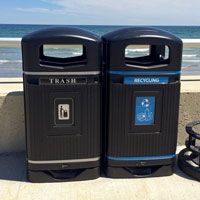 Trash and mixed recycling containers on beach front