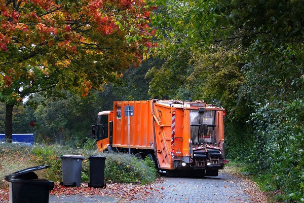 An orange recycling truck collecting waste