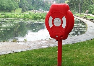 Guardian™ Life Ring Cabinet with life ring post mounted by a lake