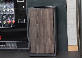 Nexus® Style Internal Trash Can in dark teak by vending machine in gym