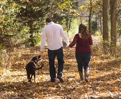 Dog walking couple in woodland area