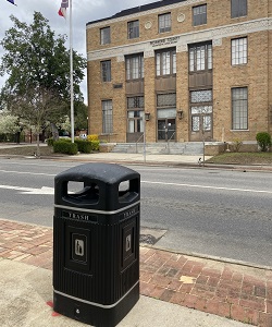 Jubilee trash can outside a building with an American flag