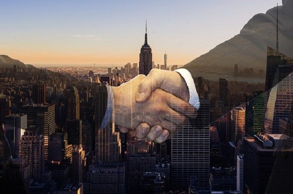 Two people shaking hands with New York City in the background