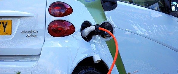 A white electric car charging at a charging point